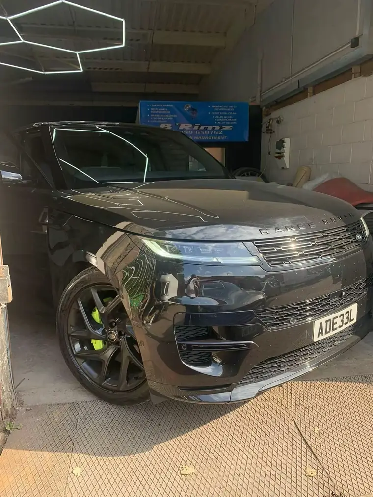 Black Range Rover with lime green brake callipers behind black wheels